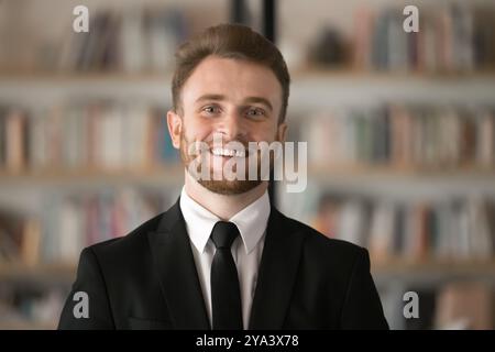 Happy handsome young Caucasian businessman looking at camera, smiling Stock Photo