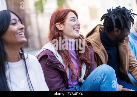 Close-up of diverse group of students sharing a joyful moment outdoors. Multicultural young people laughing together on university campus. Concept of Stock Photo