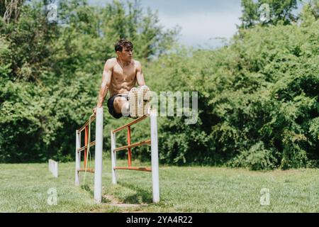 Fit man exercising outdoors performing a workout routine in nature Stock Photo