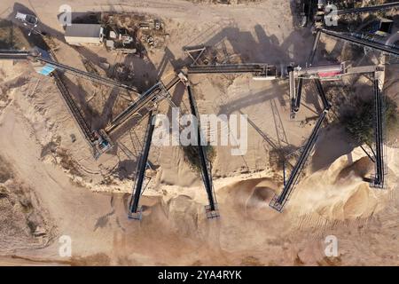 Aerial view of stone jaw crusher plant. Sand making plant and belt conveyor in mining quarry. Sand crushing and bulk materials for construction Stock Photo