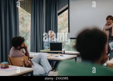 Elderly professor engaging with students in a classroom setting Stock Photo