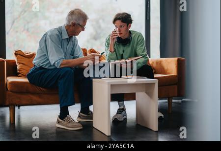 Elderly man and young adult engaged in thoughtful discussion Stock Photo