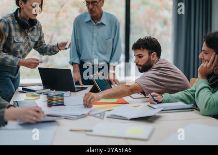 University students collaborating on a project with senior professor guidance Stock Photo