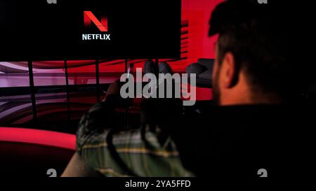 A man enjoy watching netflix on huge tv screen Stock Photo