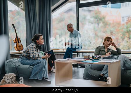 Professor engaging in discussion with attentive students in a lounge setting Stock Photo