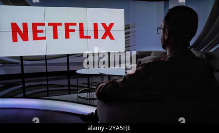 A man enjoy watching netflix on huge tv screen Stock Photo