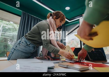 Students collaborating on creative projects in a bright classroom setting Stock Photo