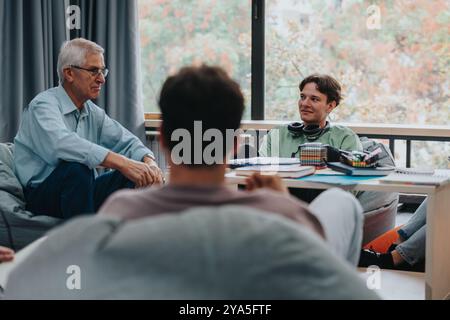 Professor engaging with attentive students in study lounge Stock Photo