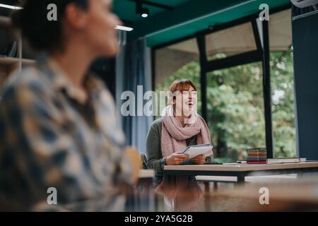 Students engaged with elderly professor in a lively classroom Stock Photo