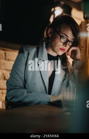 Businesswoman in an office working late, deep in thought and inspired Stock Photo