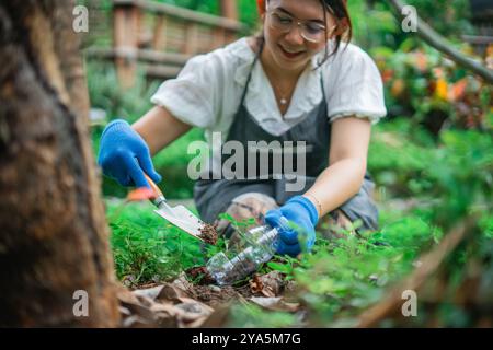 asian woman gardening using recycled plastic bottle waste Stock Photo