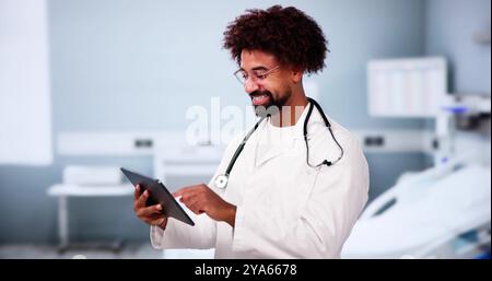 Happy African American Man Doctor In Hospital Using Tablet Computer Stock Photo