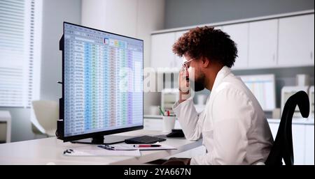 Data Analyst African Man Using Spreadsheet On Computer Stock Photo