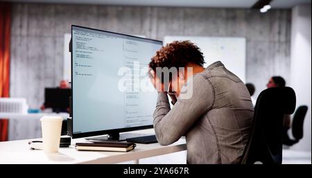 Unhappy Sad Developer Programmer Man In Stress Coding Software On Computer Stock Photo
