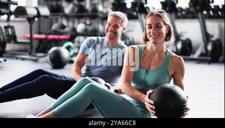 Couple Doing Abdominal Workout In Gym. Fit Athletes Stock Photo