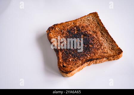 Burnt slice of toast bread isolated on white with text space without people Stock Photo