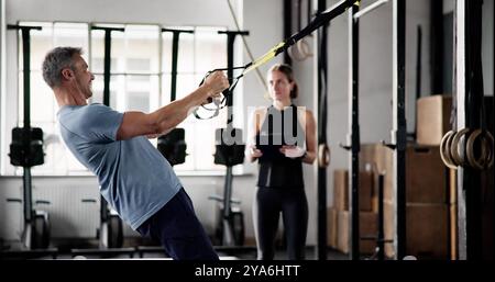 Sport Exercise In Gym. Fitness Athlete Doing Suspension Training Workout Stock Photo