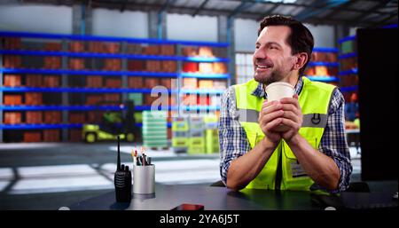 Man Enjoying Coffee And Dreaming At Storage Warehouse Stock Photo