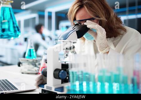 Medical Lab Scientist Woman Doing Research In Laboratory Using Microscope Stock Photo