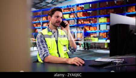 Man Calling On Mobile Phone At Warehouse Stock Photo