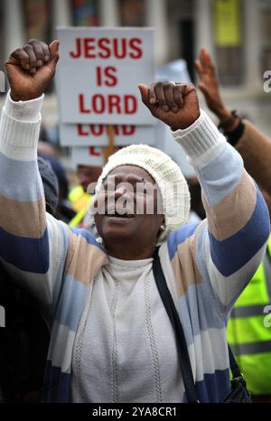 London, UK. 12th Oct, 2024. A supporter is happy in her appreciation of Jesus in front of a sign that says Jesus Is Lord during the rally. Supporters come together in Westminster to Walk for Jesus, celebrate their faith and spread love and positivity in the community. They walk, sing and pray together and share the message of Jesus with everyone around. (Credit Image: © Martin Pope/ZUMA Press Wire) EDITORIAL USAGE ONLY! Not for Commercial USAGE! Stock Photo