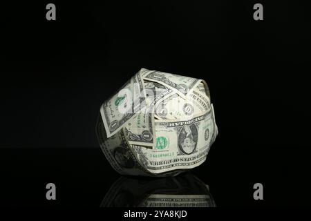 Ball made of dollars on black mirror surface Stock Photo