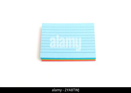 A stack of multi-colored stickers with blue in the middle. Blue is the only one that is not multicolored. Note paper isolated on white background. Stock Photo