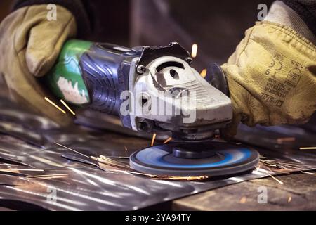 Using a handoperated angle grinder is essential for various metalworking tasks and projects Stock Photo