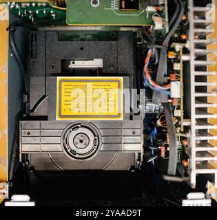 Detailed view of an optical drive with electronic components and wiring inside a device, showing internal tech mechanisms - generic warning - caution working laser mechanism Stock Photo