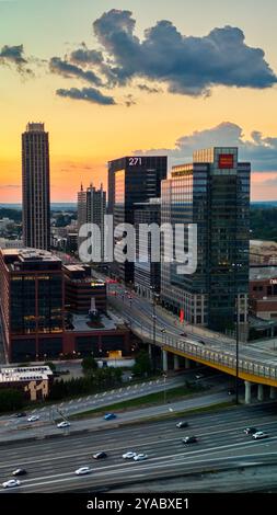 Atlanta, GA, USA: October 6,2024: Aerial Panoramic view of Midtown skyline  capturing beautiful sunset and colors in the sky and busy highway along wi Stock Photo