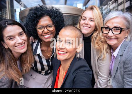 Team of women entrepreneurs having a selfie with an outdoor partner. Stock Photo