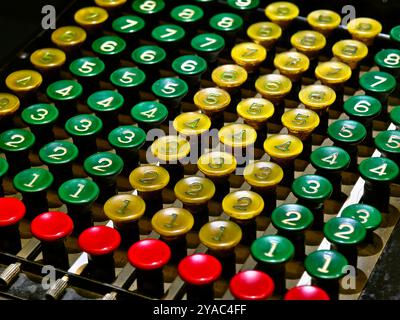 An old fashioned adding machine features a drawer located underneath it Stock Photo