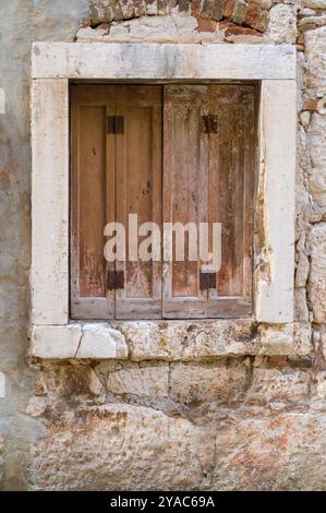 A shuttered window in an old abandoned brick house. Stock Photo