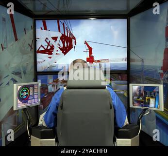 Worker in a crane simulator Stock Photo