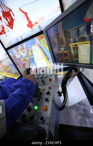 Worker in a crane simulator Stock Photo