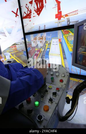 Worker in a crane simulator Stock Photo