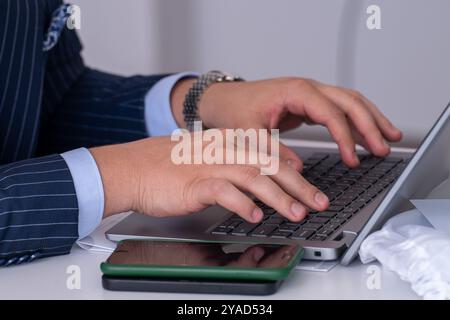Office Elegance: Man in Blue Suit Typing on Laptop Stock Photo