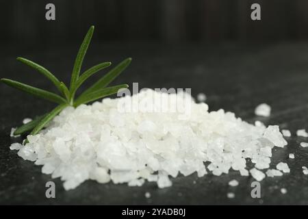 Sea salt and rosemary on dark gray textured table, closeup Stock Photo