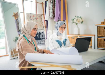 Collaborative Designers Engaged in Creative Work Within a Fashion Studio Environment Stock Photo