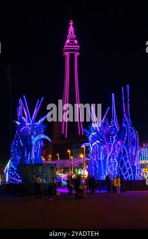 People around the light show on Blackpool promenade, with Blackpool tower in the background during Blackpool illuminations Stock Photo