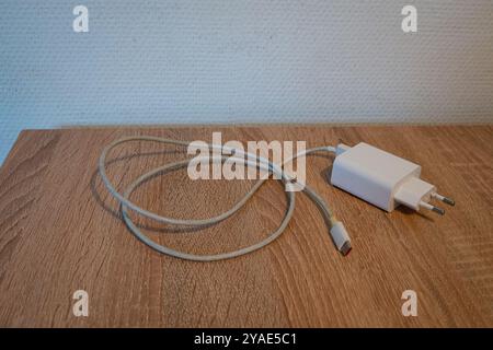 Charger with USB-C connection for a mobile phone on a table Stock Photo