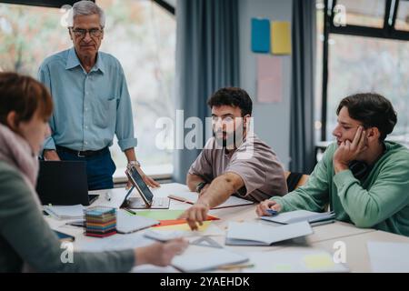 University students collaborating on a project with senior professor guidance Stock Photo
