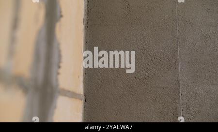 Construction worker applying plaster on a brick wall using a spatula. Stock Photo