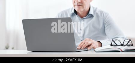Unrecognizable senior man using laptop at home Stock Photo