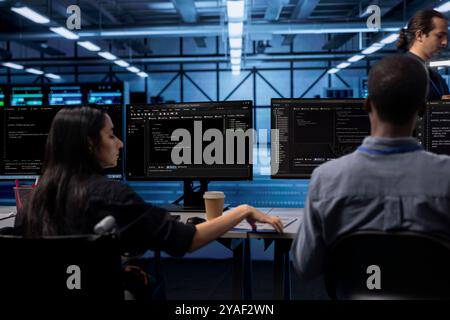 Person with paraplegia and colleague working in inclusive server farm facility, doing maintenance job. Engineer in wheelchair and technician doing tasks in data center housing advanced gear Stock Photo