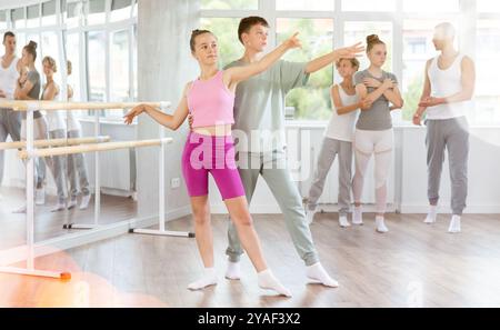 Ballet studio - teenagers girls and boys learn ballet movements in pairs Stock Photo