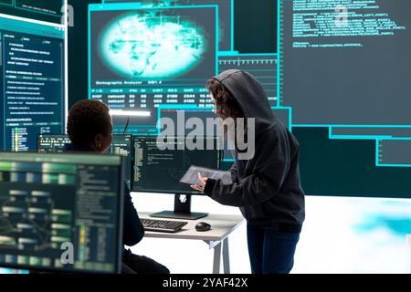 Cyber security specialist conducting cyber surveillance and threat detection in a governmental agency. Professional hackers team managing cybercrime prevention and malware detection. Stock Photo