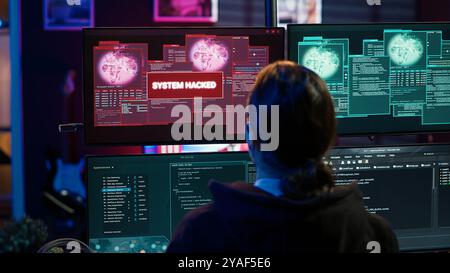 Happy hacker in apartment having burst of joy after managing to steal valuable data, using phishing technique that tricks users into revealing sensitive information, camera A Stock Photo