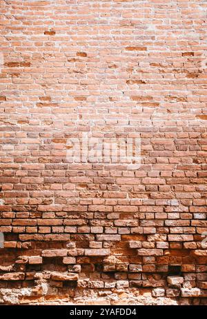 A brick wall is a sturdy structure made of bricks and mortar. It provides privacy, security, and aesthetic appeal to buildings. durability and timeles Stock Photo