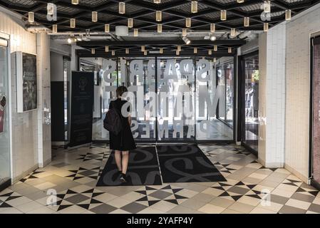 Uppsala, Uppland Sweden, 07 27 2019 Beautiful thirty year old woman in black dress walkig out of the Svava Matgalleria shopping mall Stock Photo